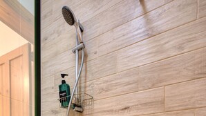 A bathroom with a wooden wall, a showerhead, a handheld shower, and a shampoo bottle on a soap dish. - The Beach Apartment - Sliema (Sliema)