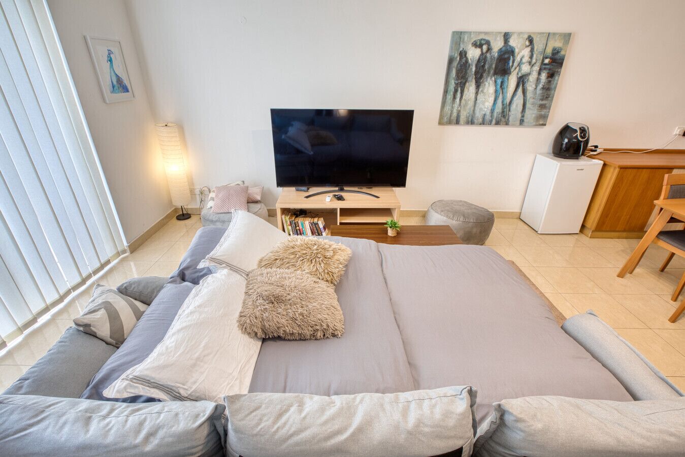 Une chambre moderne avec un grand lit, une télévision, un bureau et une chaise.