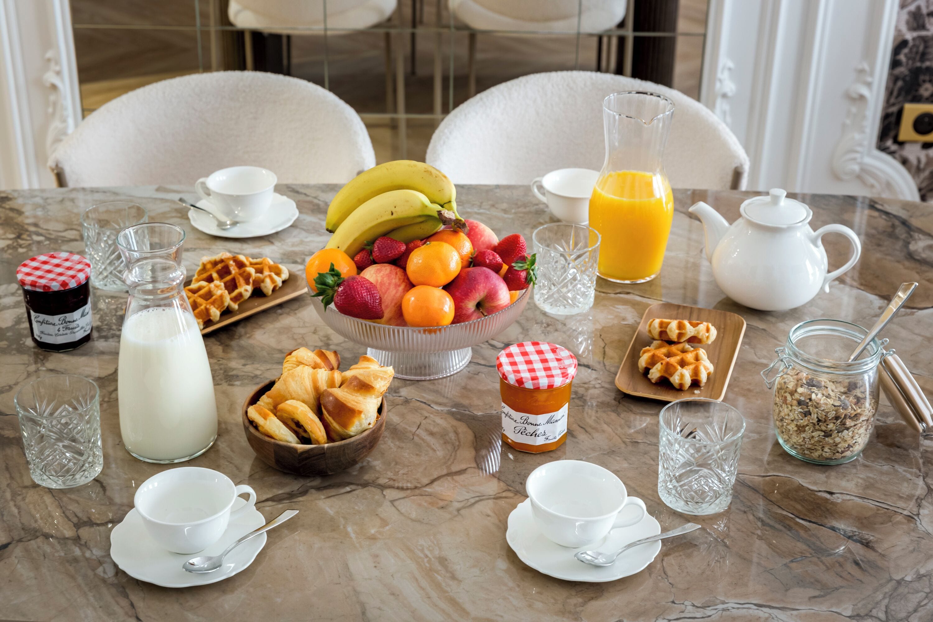 Une table de petit-déjeuner avec divers aliments et boissons.