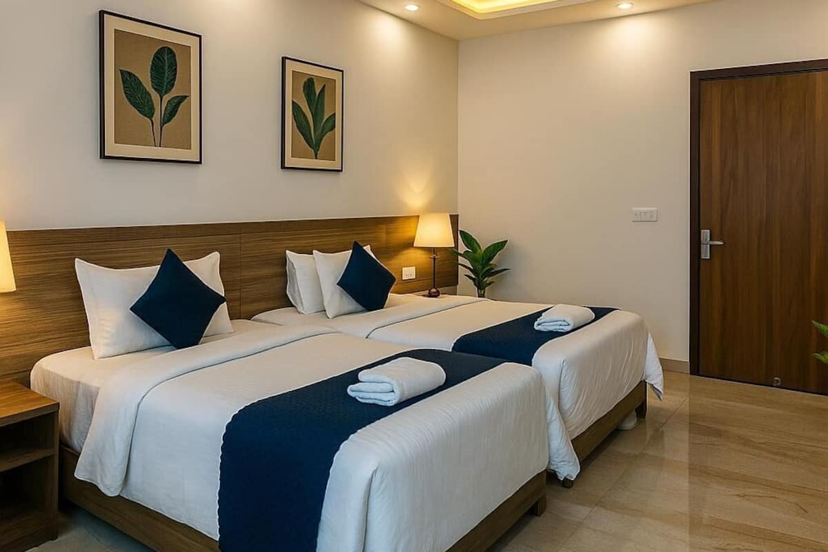 Een hotelkamer met een tweepersoonsbed, twee nachtkastjes, een plafondventilator en twee wandplanten.