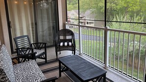 A balcony with a sofa, chairs, and a table. - Edge of Paradise-no steps,GREAT LAKE VIEW-fish, golf, pools, tennis, pickleball (Branson)
