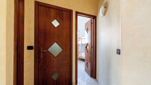 Une porte en bois ornée d’une fenêtre en forme de losange et d’une poignée en laiton.