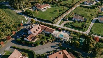 An aerial view of a residential area with houses, roads, and a swimming pool.