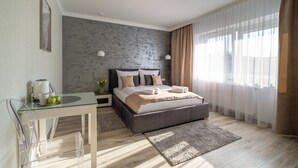 A modern bedroom with a bed, bedside table, and a glass table with a kettle and apples. - Panorama Park (Świnoujście)