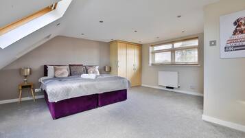 A bedroom with a bed, a nightstand, a wardrobe, a window, and a radiator.