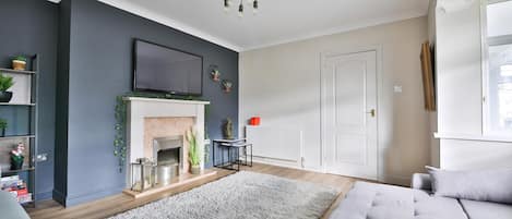 A living room with a fireplace, a television, and a sofa.