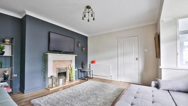 A living room with a fireplace, a television, and a sofa.