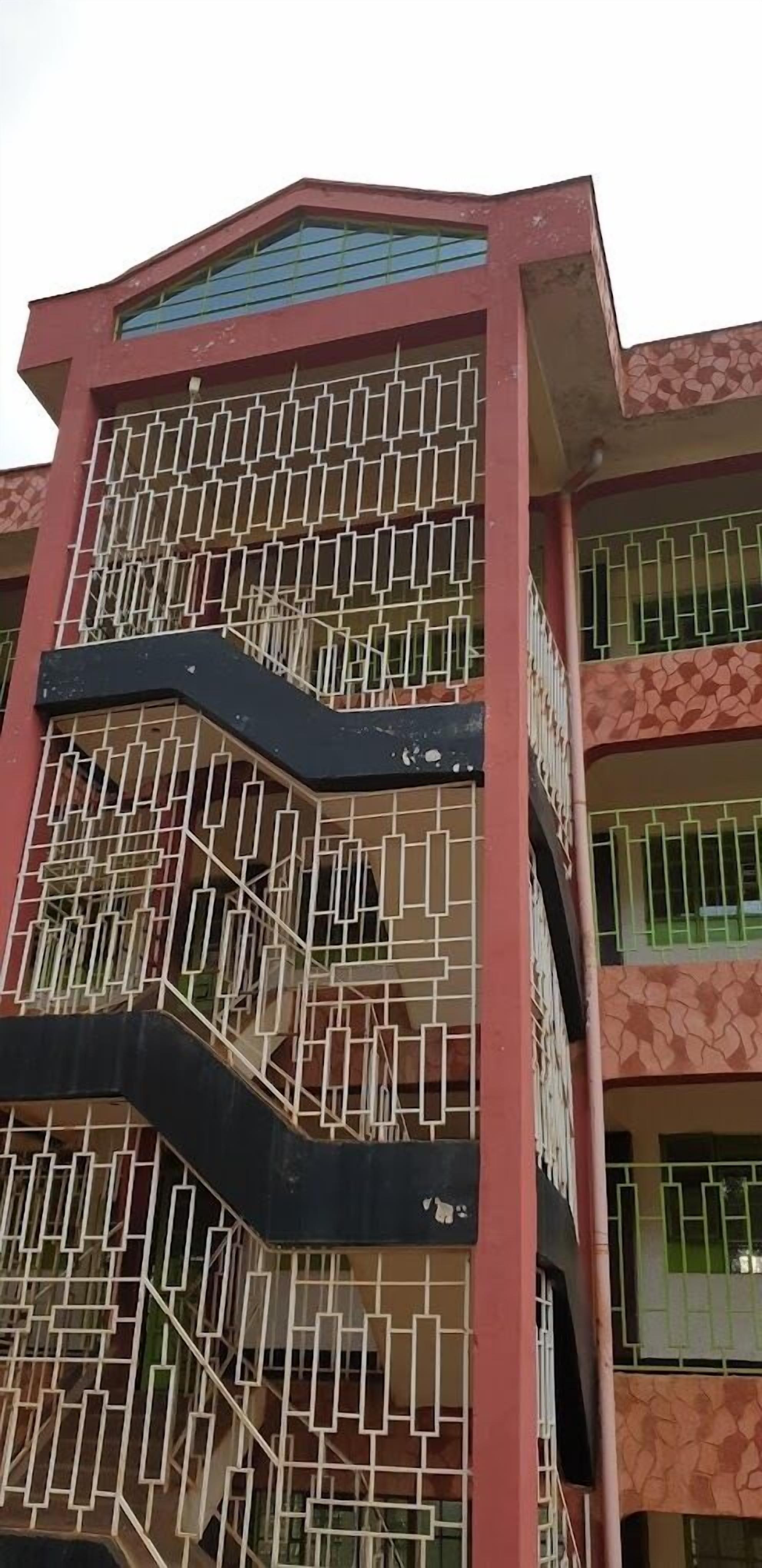 Un edificio de varios pisos con fachada geométrica y ventanas con barrotes.