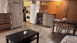 Een compact verblijf met kitchenette, een eethoek en een klein zithoekje.