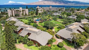 Un resort con varias edificaciones, piscina y vista al océano.