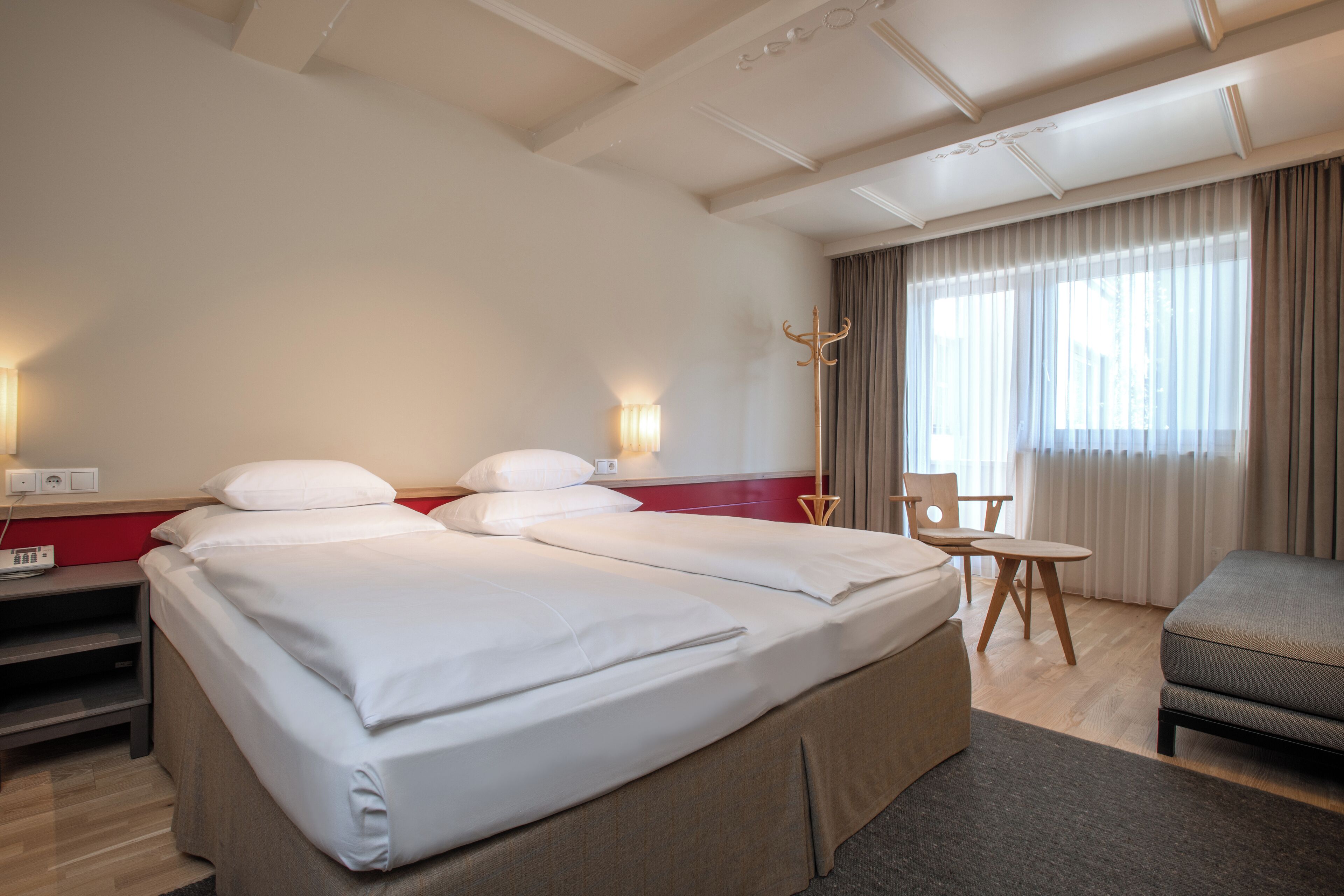 A hotel room with a large bed, a desk, a chair, and a sofa.