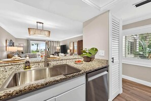 A modern kitchen with granite countertops, stainless steel appliances, and a built-in dishwasher.