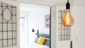 Una camera da letto moderna con un letto, un comodino e una lampada a parete.