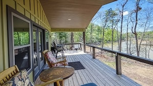 A covered deck with outdoor furniture, a table, and chairs. - The Lake Cottage on the Peninsula.  (Dandridge)
