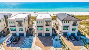 A beachfront residential complex with multiple two-story buildings, parking spaces, and a beach view. - NEW Rental!!! Viviana 11 - Private Pool Beach Front Home - Sleeps 14 (Perdido Key)