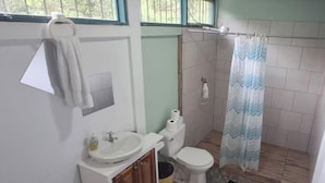 A bathroom with a toilet, sink, and shower curtain. - Room-mountain Retreat in Bijagua de Upal (Bijagua)