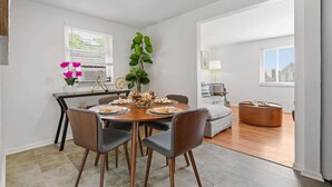 Un comedor moderno con una mesa redonda, sillas y una planta en maceta.