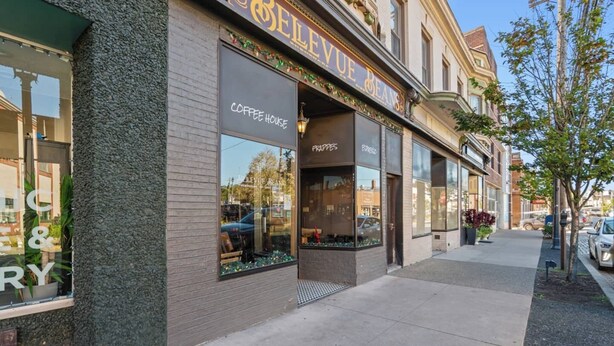 Una cafetería con grandes ventanales y un cartel que dice "BELLEVUE BEANS".