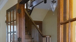 Una escalera de madera con una puerta de vidrio a la izquierda y una puerta de madera a la derecha.