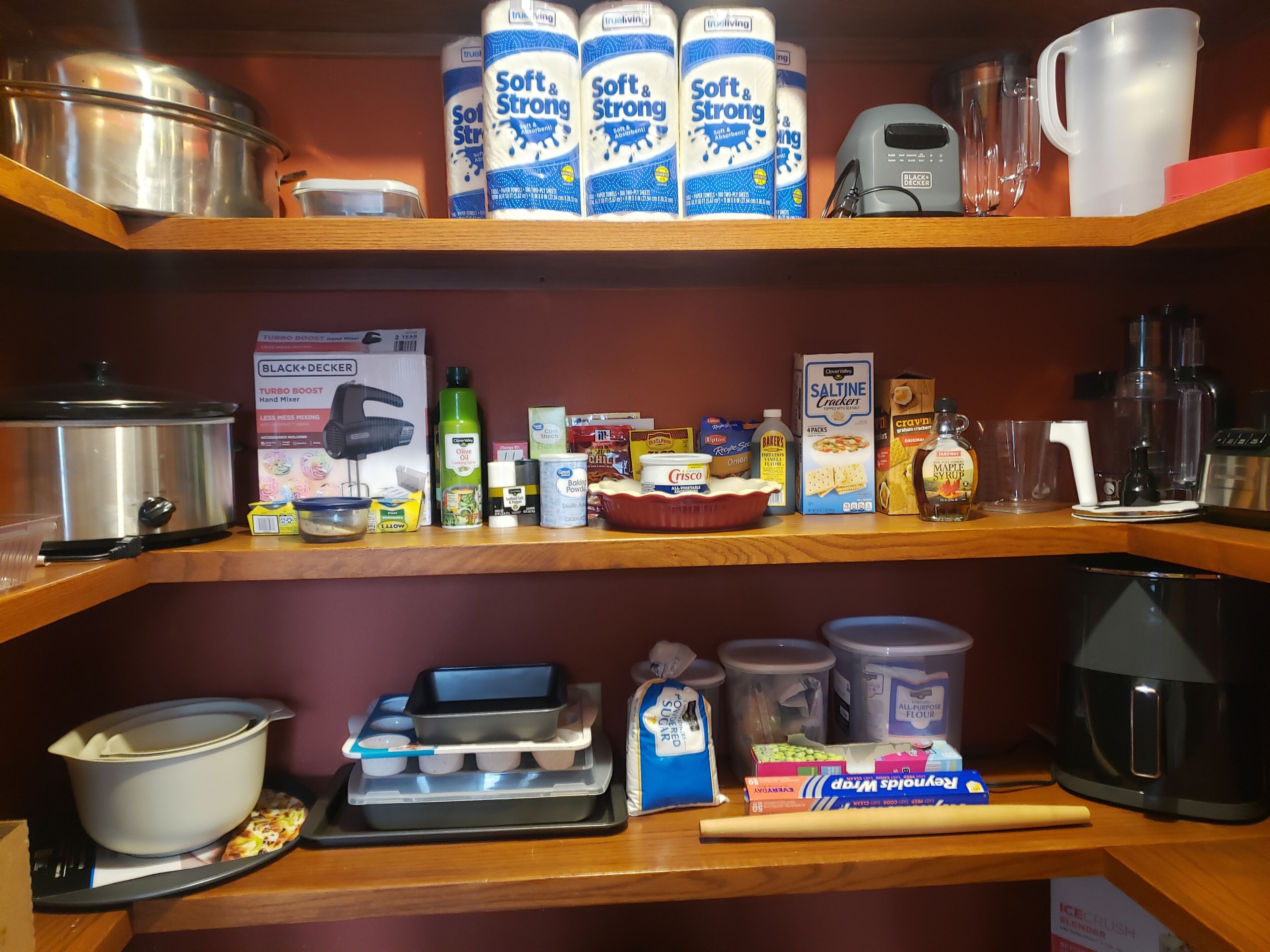 Una cocina con diversos ingredientes y utensilios de cocina, incluyendo una olla, una batidora y varios recipientes.