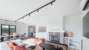 Una sala de estar moderna con chimenea, zona de estar y comedor.