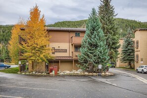 A building with a sign reading "Snowdance" and a parking lot in front. - Snowdance C304 2 Bedroom Condo (Keystone)