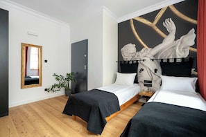 A hotel room with two beds, a large mirror, a potted plant, and a mural on the wall.