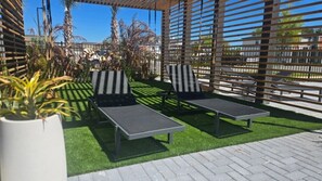 Two lounge chairs with a view of a parking lot and buildings in the background.