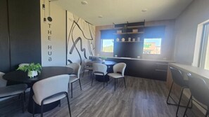 A modern kitchen with a black countertop, white chairs, and a dining table.