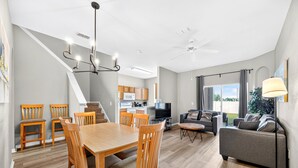 Un appartement moderne comprenant un coin repas, une cuisine, un salon et un balcon.