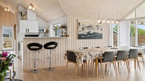 Eine moderne Küche mit Holzausstattung, einer Mikrowelle und einem Essbereich mit Tisch und Stühlen.