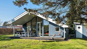 A modern house with a covered patio, a dining area, and a small shed. - 5 Star Holiday Home in Vordingborg (Vordingborg)