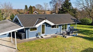 A blue house with a sloped roof, a covered patio, and a small garden area. - 5 Star Holiday Home in Vordingborg (Vordingborg)