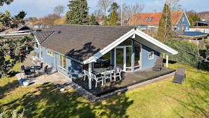 A modern house with a large deck, outdoor seating, and a covered patio area. - 5 Star Holiday Home in Vordingborg (Vordingborg)
