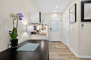 A modern kitchen with white cabinets, a black countertop, and a potted orchid.