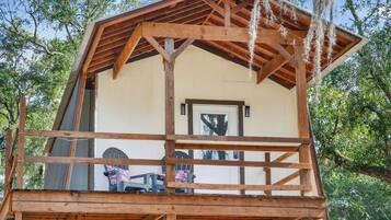A wooden cabin with a porch and a covered deck area.