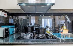 Una cocina con extractor de acero inoxidable, cafetera y dispensador de agua.