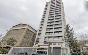 Un edificio de varios pisos con diseño moderno, que cuenta con balcones y ventanas amplias.