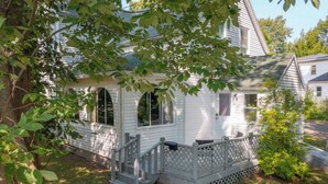 A white house with a porch and a small staircase leading to the entrance. - Stylish 1 bedroom ap in downtown (Antigonish)
