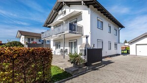 Een huis met twee verdiepingen, een balkon, een garage en een verharde oprit.