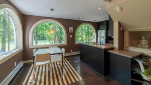 A modern kitchen with a central island, large windows, and a dining area with striped rugs. - 2 Unit house across from the hospital (Antigonish)