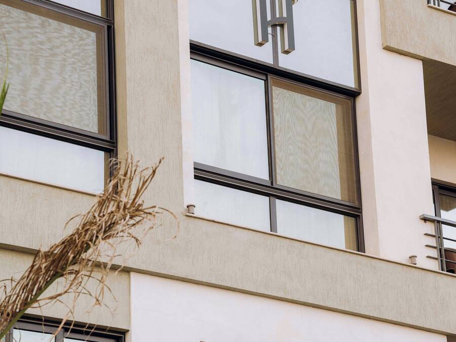 Un edificio de varios pisos con amplias ventanas y un llamativo logotipo 'H' en la fachada.
