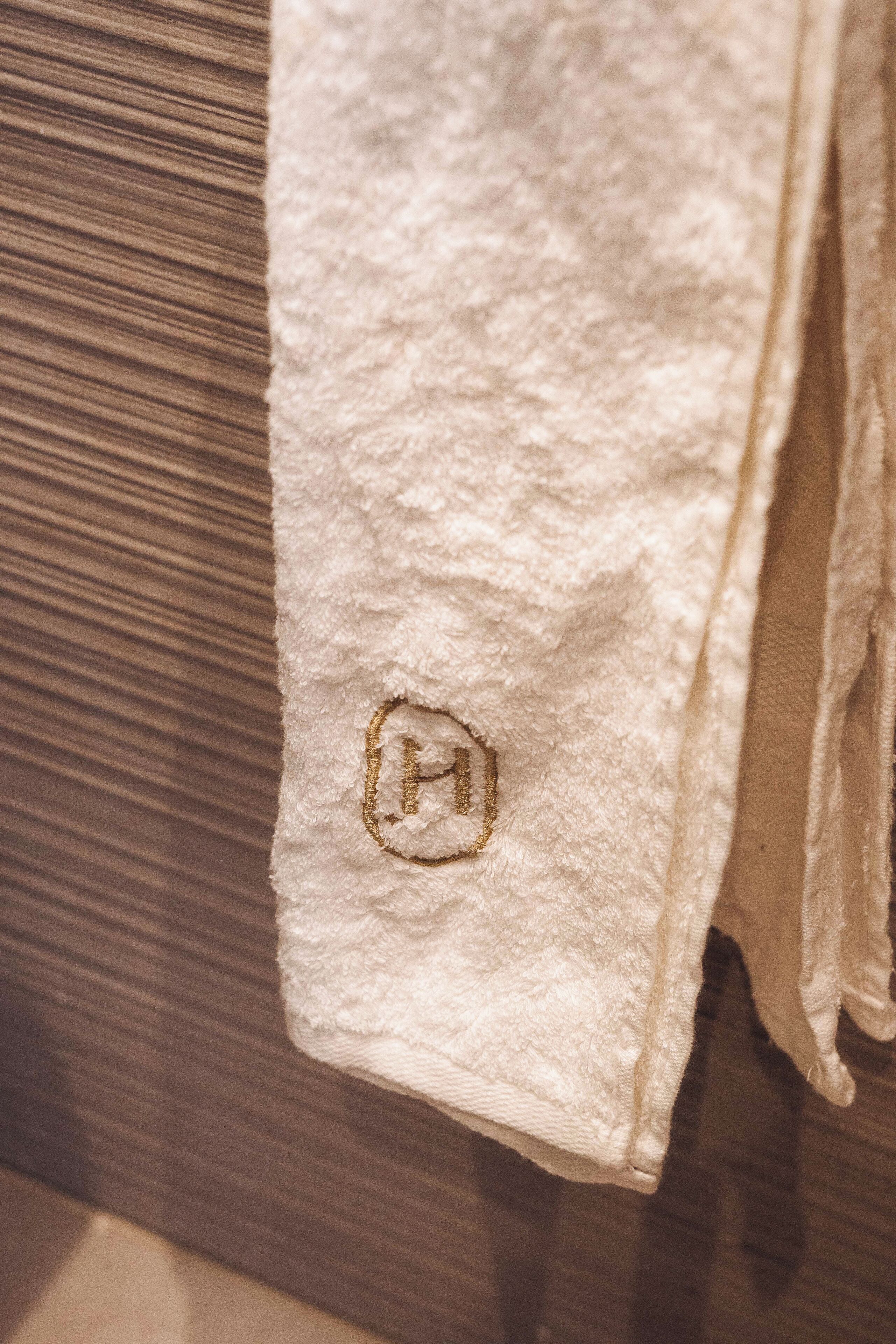 A white towel with a logo on a wooden surface.
