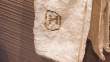 A white towel with a logo on a wooden surface.