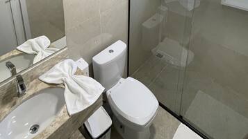Un baño con lavamanos, inodoro y ducha.