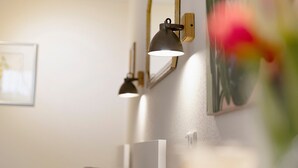 A bedroom with a bed, bedside table, lamp, and a framed picture on the wall. - Studio Apartment, 32 sqm, with Wi-Fi (Ammerbuch)
