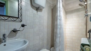 A bathroom with a sink, toilet, shower, and a mirror with a geometric frame. - GuestHost - Lovely Apartment in the Perugian Hills (Bagnaia)