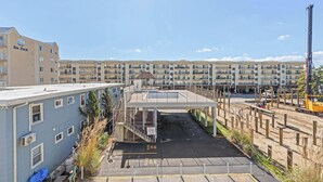 A multi-story hotel with a covered walkway and a construction site nearby. - Silver Sun 201 (Ocean City)