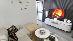 A modern living room with a sofa, coffee table, and a fireplace.