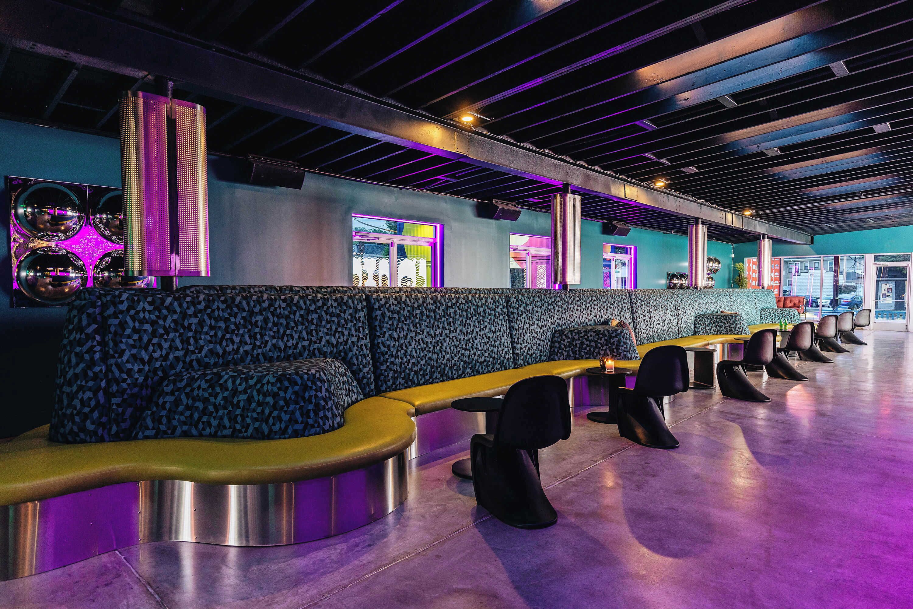 A modern lounge area with seating and a large illuminated speaker.